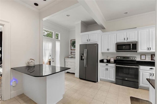 264 Mcdonald Ave, Mobile, AL 36604 - kitchen with stainless steel appliances, dark countertops, white cabinetry, crown molding, and a peninsula