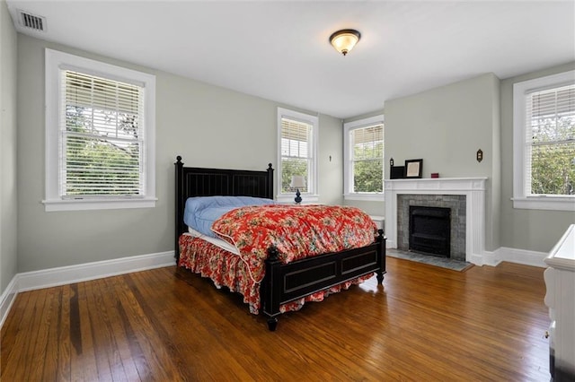 264 Mcdonald Ave, Mobile, AL 36604 - bedroom featuring wood finished floors, multiple windows, and a fireplace with flush hearth