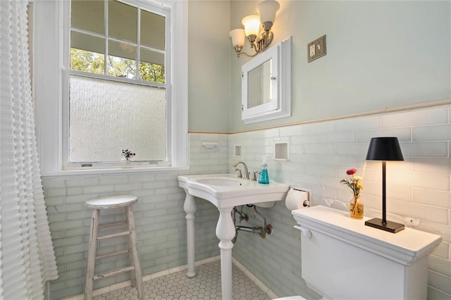 264 Mcdonald Ave, Mobile, AL 36604 - bathroom featuring a wainscoted wall, a chandelier, tile patterned flooring, and tile walls