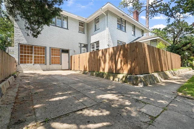 264 Mcdonald Ave, Mobile, AL 36604 - rear view of house with a chimney, a patio, and brick siding