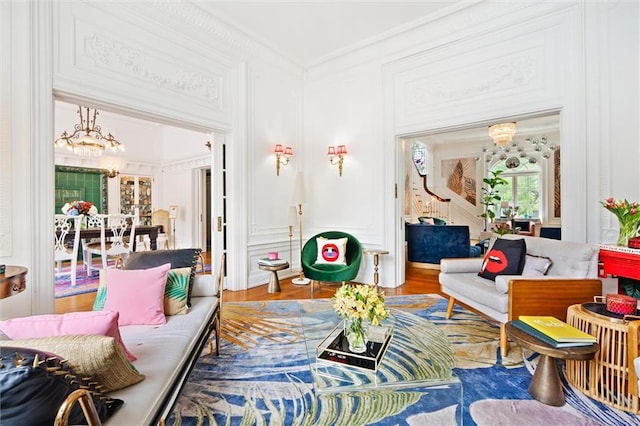 living room featuring a notable chandelier, hardwood / wood-style flooring, and crown molding