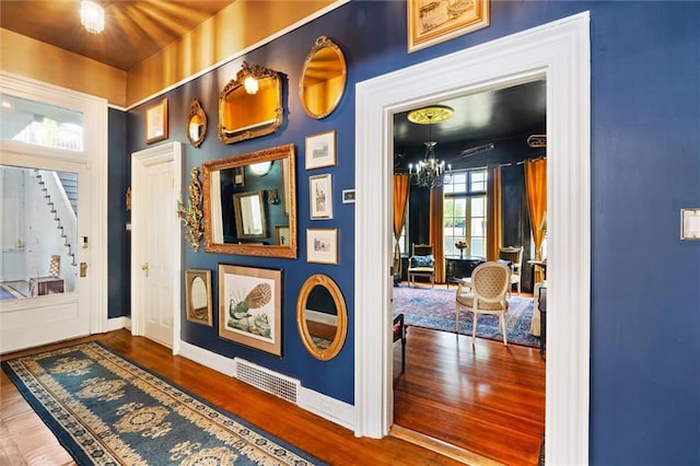 foyer entrance featuring hardwood / wood-style floors and a chandelier