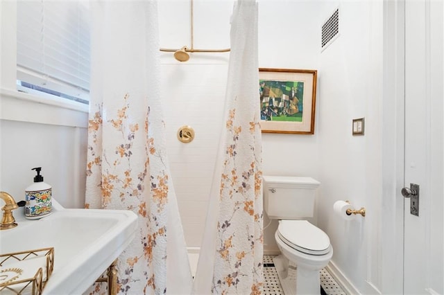 bathroom featuring sink, tile flooring, and toilet