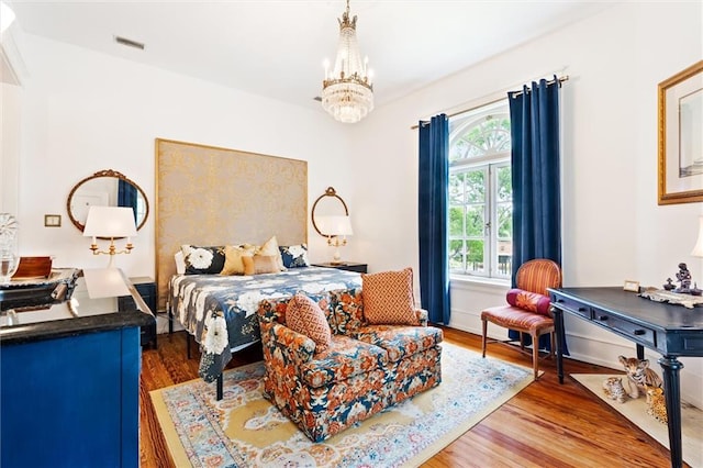 bedroom featuring a notable chandelier and dark wood-type flooring