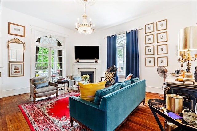 living room featuring a notable chandelier, a healthy amount of sunlight, and dark wood-type flooring