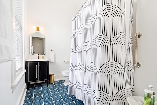 bathroom featuring tile flooring, vanity, and toilet