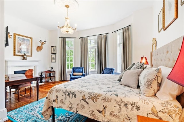 bedroom with an inviting chandelier and hardwood / wood-style floors