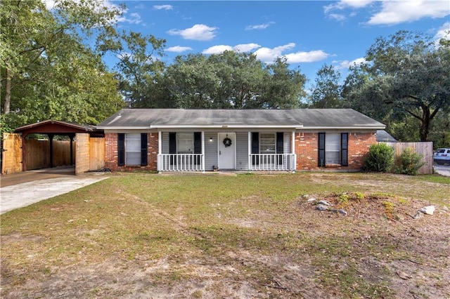 ranch-style home featuring a front lawn, covered porch, and a carport