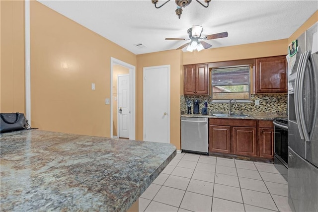 kitchen featuring appliances with stainless steel finishes, tasteful backsplash, ceiling fan, sink, and light tile patterned flooring