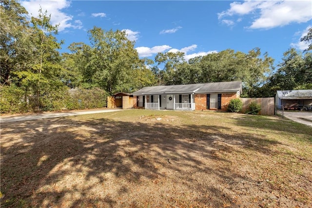 single story home with a porch and a storage shed