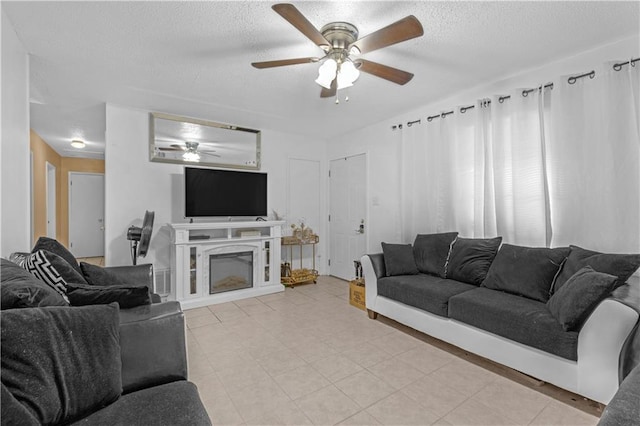 living room with ceiling fan and a textured ceiling