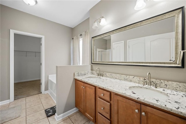 bathroom featuring tile patterned floors, vanity, and a tub to relax in