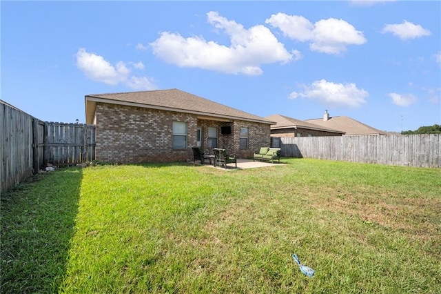 rear view of house featuring a lawn and a patio area