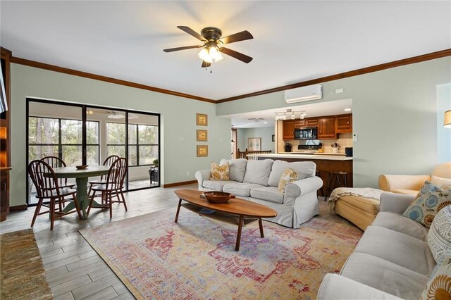 living area with crown molding, light wood-style flooring, an AC wall unit, ceiling fan, and baseboards