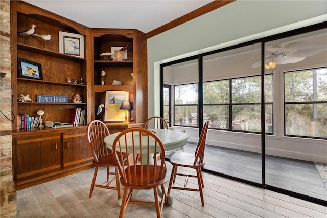 dining area featuring light wood-style floors, baseboards, built in shelves, and a ceiling fan