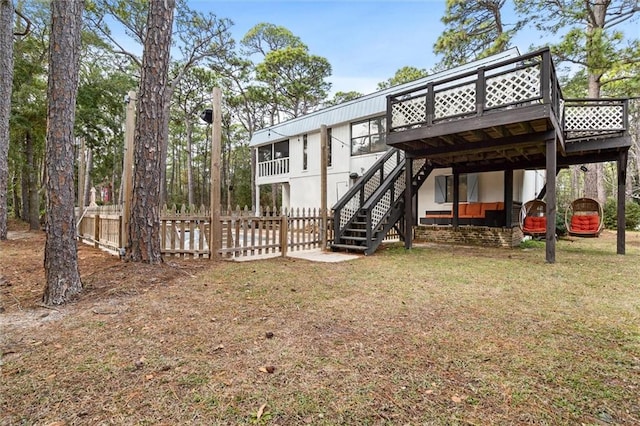 back of property with a lawn, stairway, fence, a wooden deck, and a carport