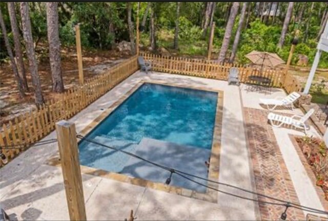 view of pool featuring a patio and fence