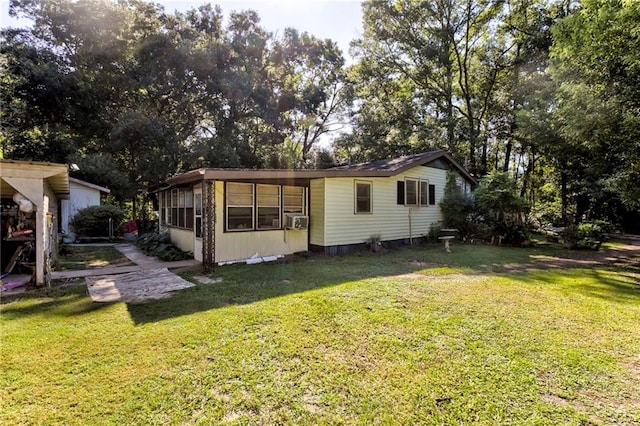 back of property featuring a lawn and cooling unit