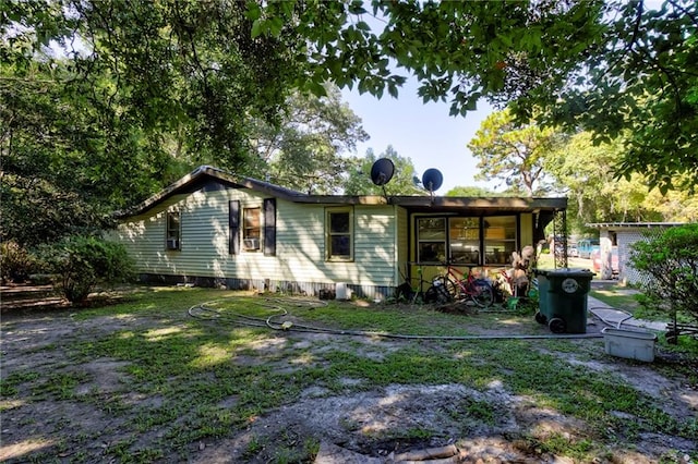 rear view of house featuring a lawn