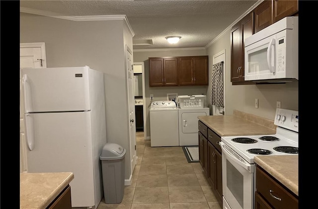 kitchen with crown molding, a textured ceiling, light tile patterned floors, white appliances, and washer and dryer