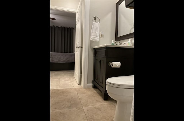 bathroom with toilet, vanity, and tile patterned flooring