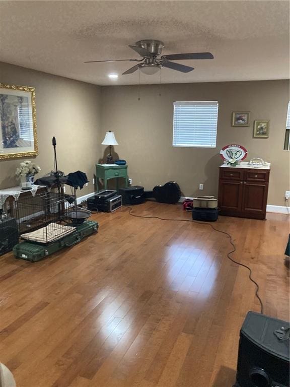 misc room featuring a textured ceiling, ceiling fan, and light hardwood / wood-style flooring