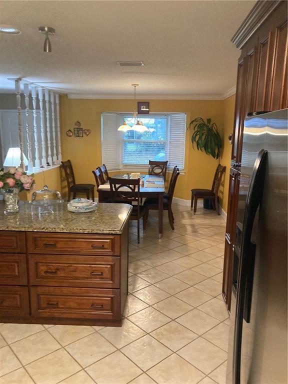 kitchen featuring light stone counters, ornamental molding, hanging light fixtures, a notable chandelier, and stainless steel fridge