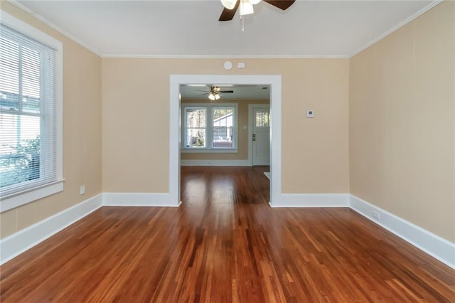 empty room featuring dark wood-type flooring, ceiling fan, and crown molding