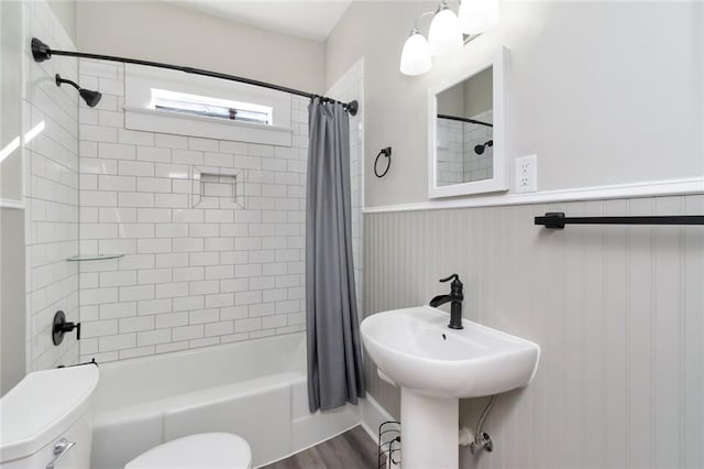 full bathroom with sink, wood-type flooring, shower / bath combo, and toilet