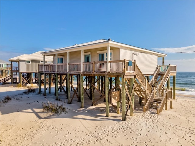 rear view of property featuring a carport, a beach view, and a water view