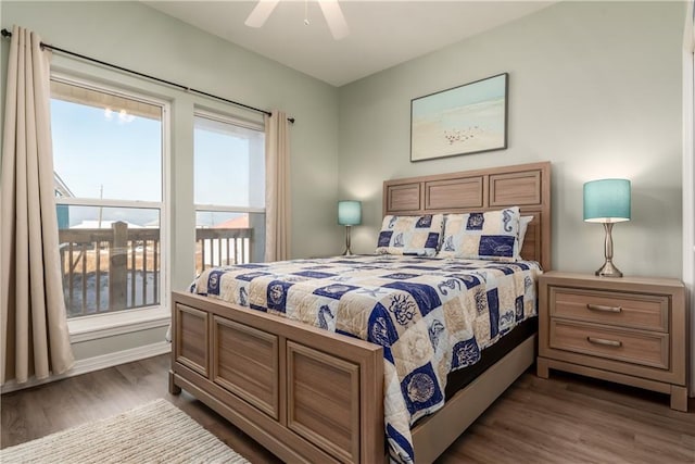 bedroom with dark wood-style floors, a ceiling fan, and baseboards