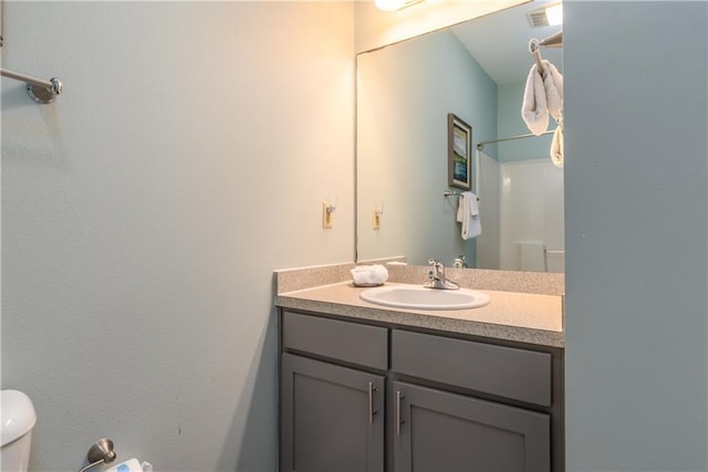 bathroom with visible vents, vanity, and toilet