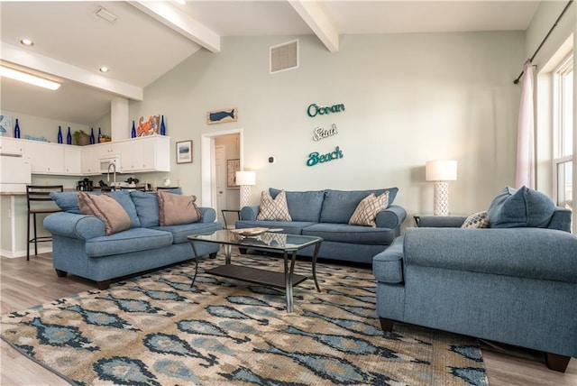 living room with high vaulted ceiling, visible vents, wood finished floors, and beamed ceiling