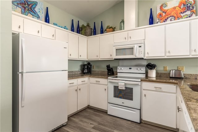 kitchen with dark wood-type flooring, white cabinets, a sink, dark stone countertops, and white appliances