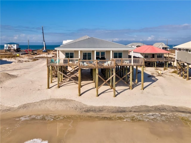 back of property with a water view and a view of the beach