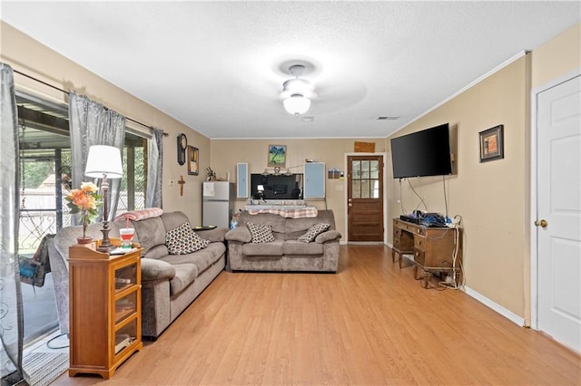 living room featuring ornamental molding, ceiling fan, hardwood / wood-style floors, and a textured ceiling