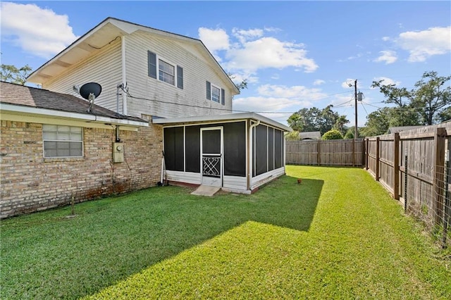 rear view of house with a sunroom and a yard