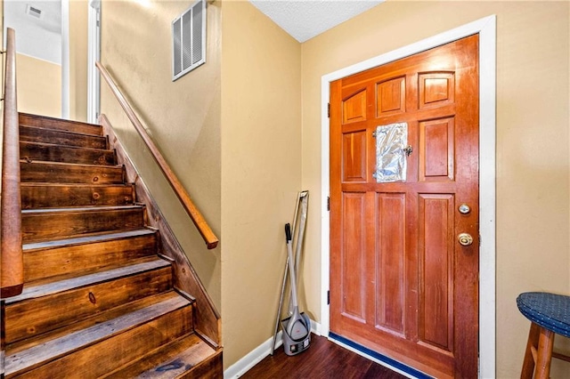 foyer featuring a textured ceiling and dark hardwood / wood-style floors