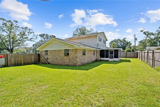 back of house with a yard and a sunroom