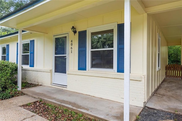 4061 Sallie Ct, Mobile, AL 36609 - doorway to property featuring covered porch, brick siding, and board and batten siding