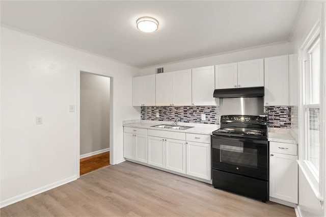 4061 Sallie Ct, Mobile, AL 36609 - kitchen with black / electric stove, under cabinet range hood, white cabinets, decorative backsplash, and light wood-style floors