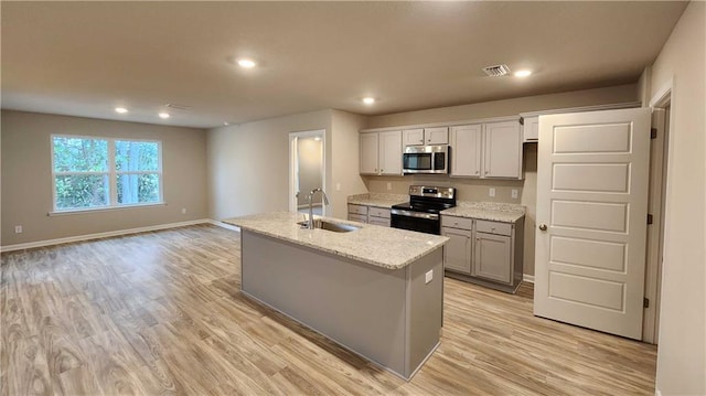 5189 Pinyon Dr, Mobile, AL 36693 - kitchen featuring a sink, a center island with sink, light wood finished floors, appliances with stainless steel finishes, and visible vents