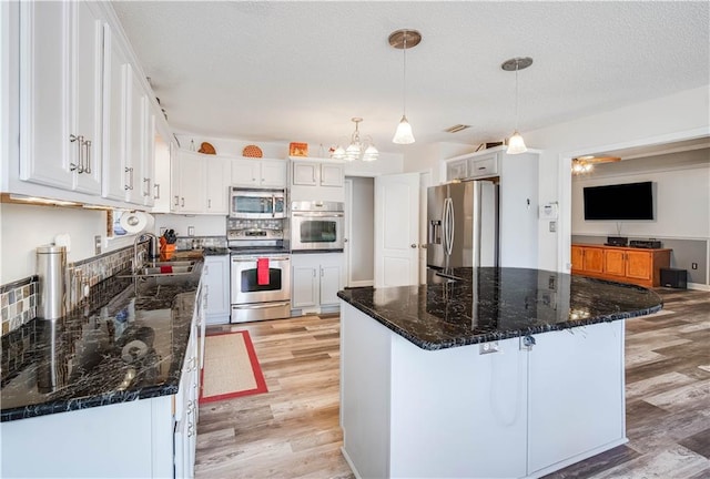 kitchen with white cabinetry, a center island, light hardwood / wood-style flooring, pendant lighting, and appliances with stainless steel finishes