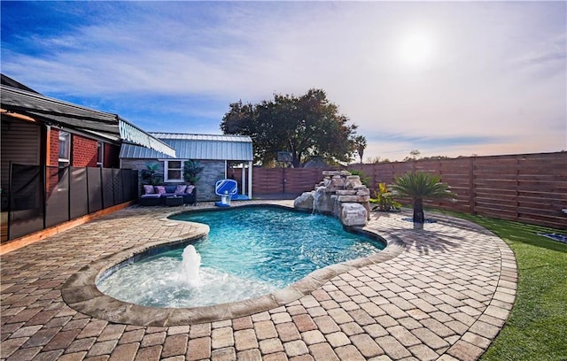 pool at dusk with pool water feature and a patio area