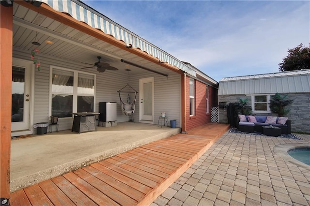 wooden terrace featuring ceiling fan, an outdoor hangout area, and a patio