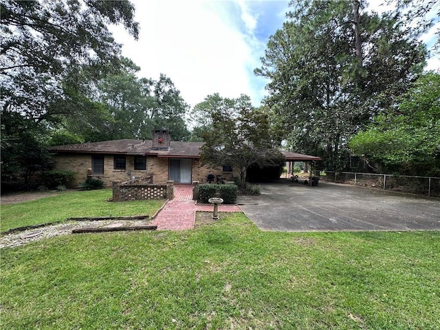 5859 Chalet Dr N, Mobile, AL 36608 - rear view of property featuring concrete driveway, brick siding, a carport, and a chimney