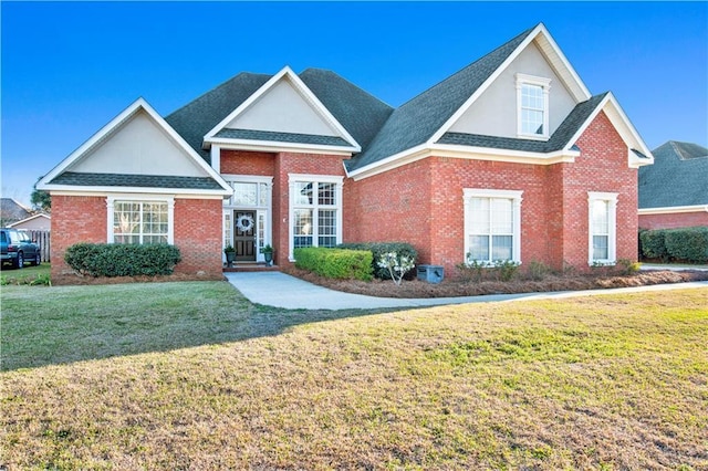 traditional-style home featuring brick siding, roof with shingles, and a front yard