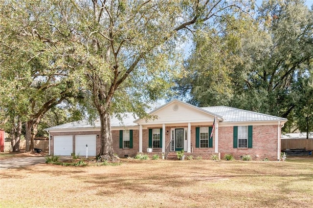 view of front of house featuring an attached garage, brick siding, fence, crawl space, and a front lawn