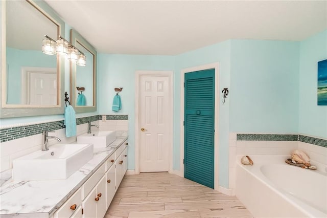 bathroom with double vanity, a garden tub, decorative backsplash, and a sink