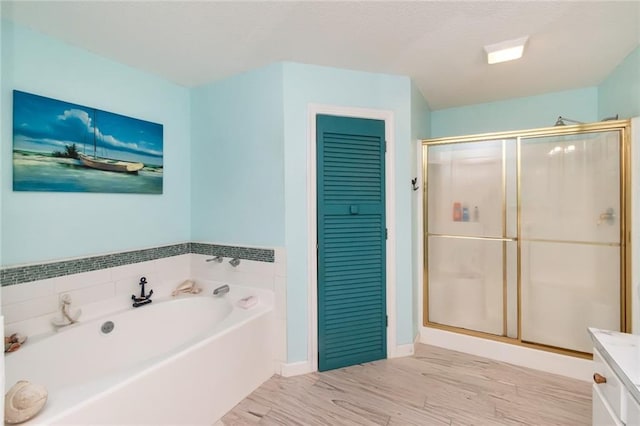 full bathroom featuring wood finished floors, a shower stall, baseboards, and a bath